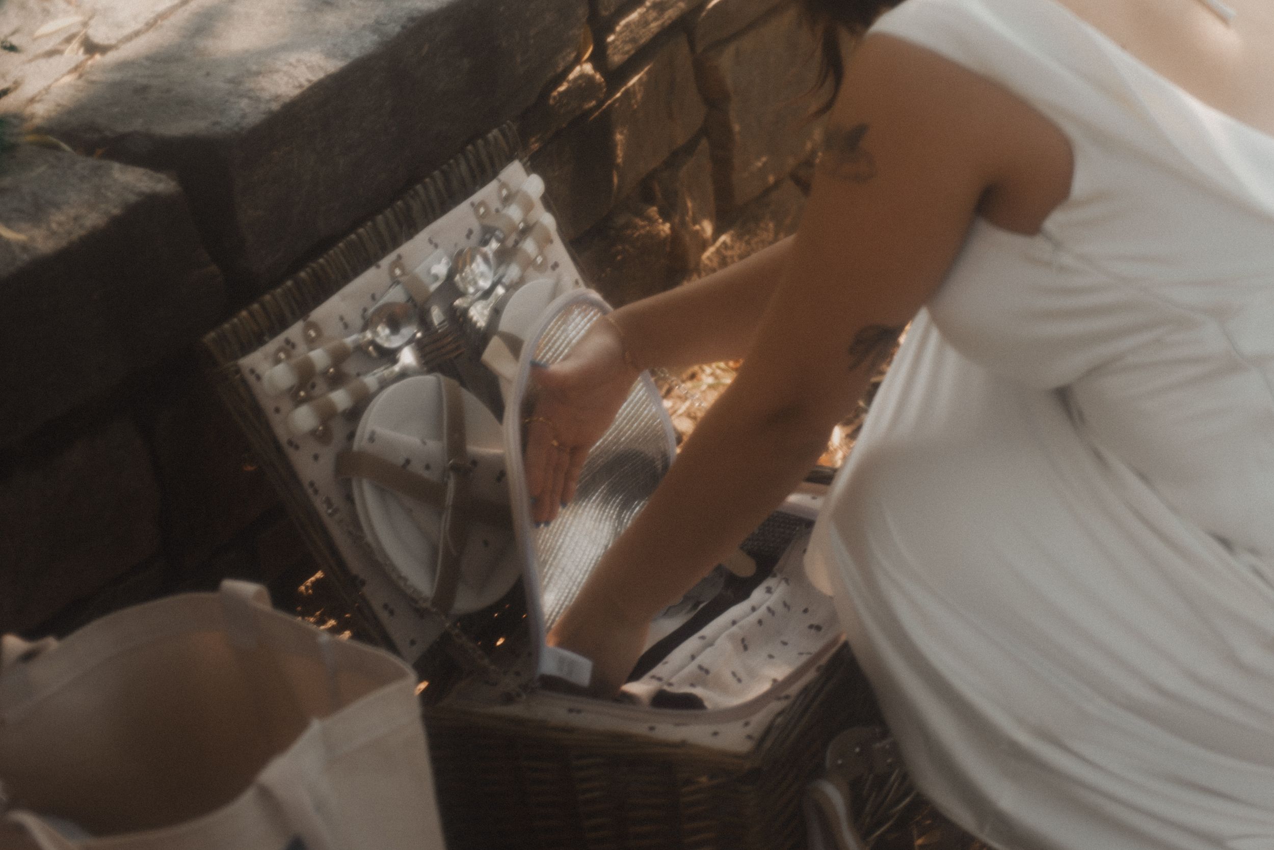 Close-up detail of vintage picnic setup with white dress in frame.