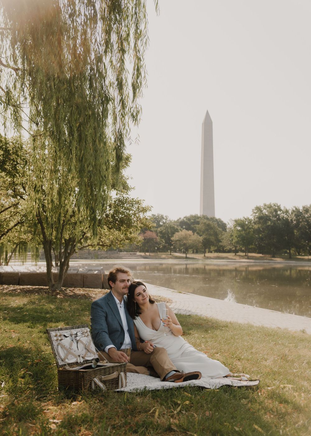 Romantic picnic scene near reflecting pool with Washington Monument in background.