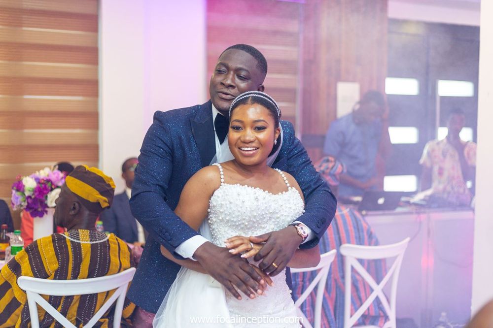 Candid wedding reception moment captured in warm ambient lighting.