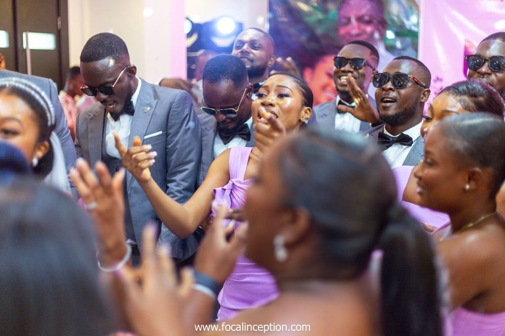 Energetic wedding reception scene with guests dancing and celebrating.