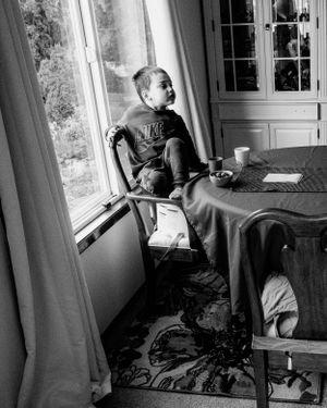 A black and white photo of a quiet moment at a window seat.