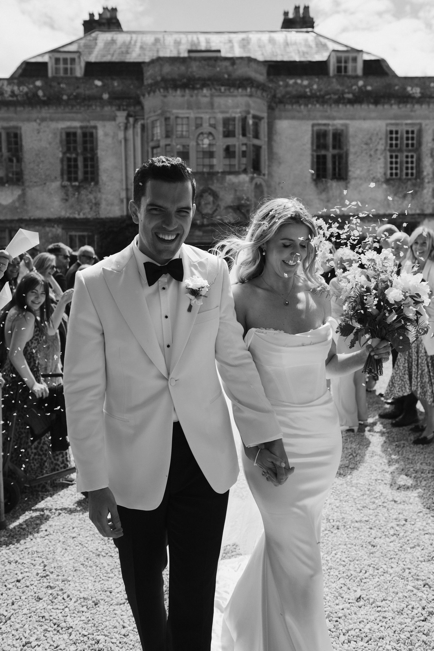 bride and groom walking through confetti tunnel at hasmwell house in bath