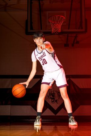 Individual basketball players pose confidently in uniform, capturing strength, focus, and determination in dynamic sports portraits.