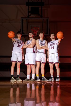 A small basketball group poses for a sharp, confident portrait session, showcasing unity and team pride with focused expressions.