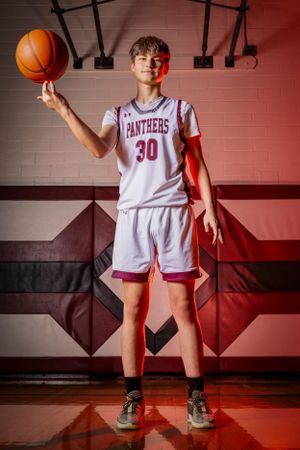 Individual basketball players pose confidently in uniform, capturing strength, focus, and determination in dynamic sports portraits.