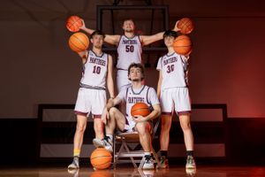 A small basketball group poses for a sharp, confident portrait session, showcasing unity and team pride with focused expressions.