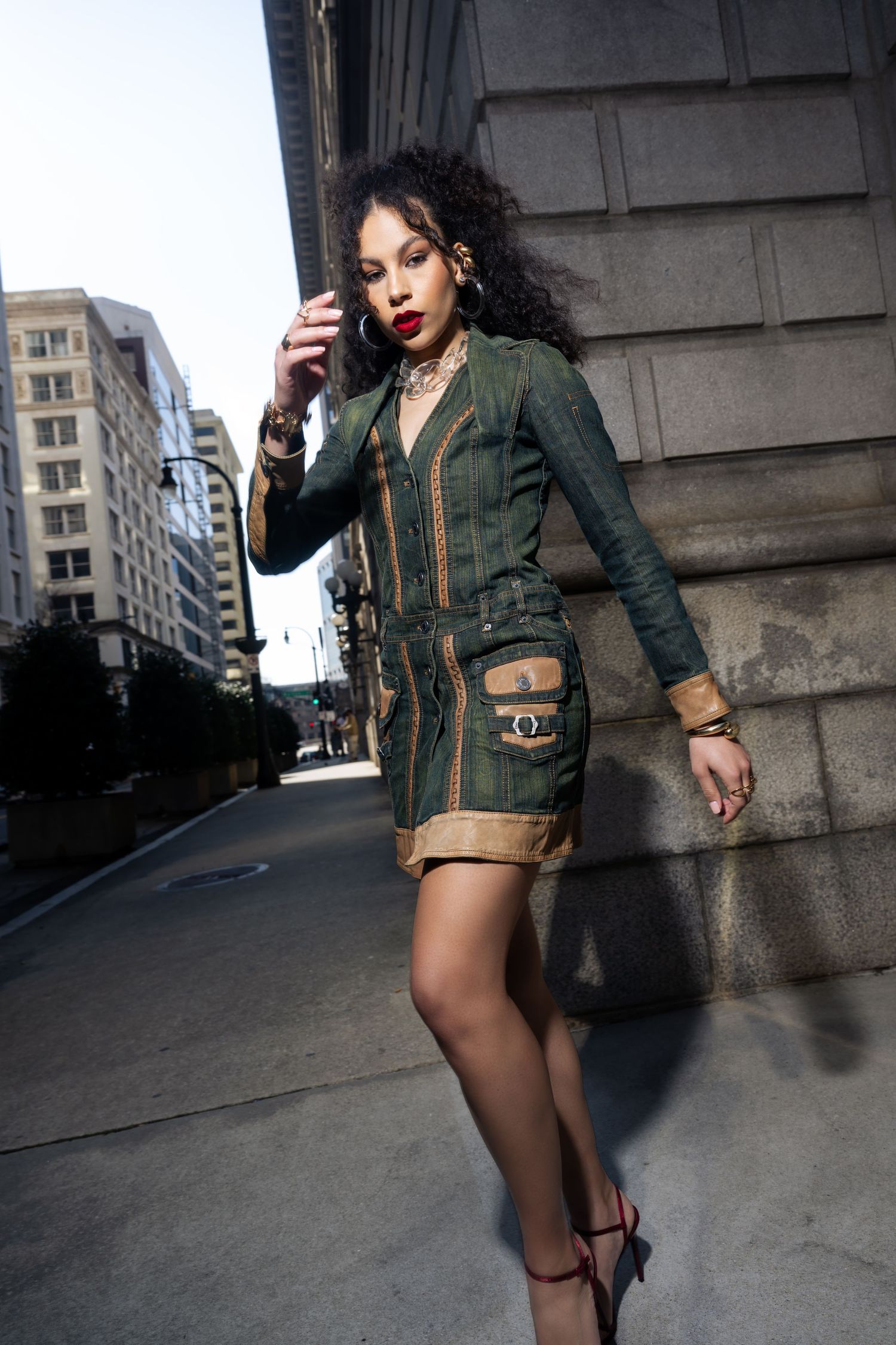 Street style portrait in green Dior dress against urban architecture.