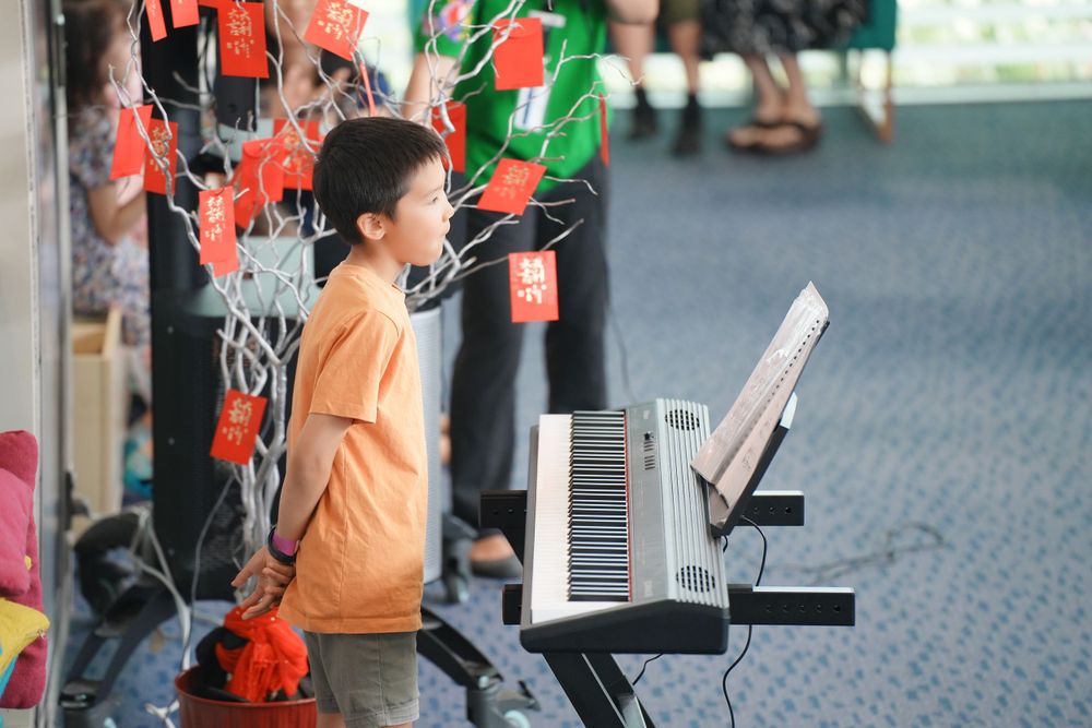 Library New Year event photography featuring a beautiful traditional Hanfu Guzheng performance, by an Auckland photographer.
