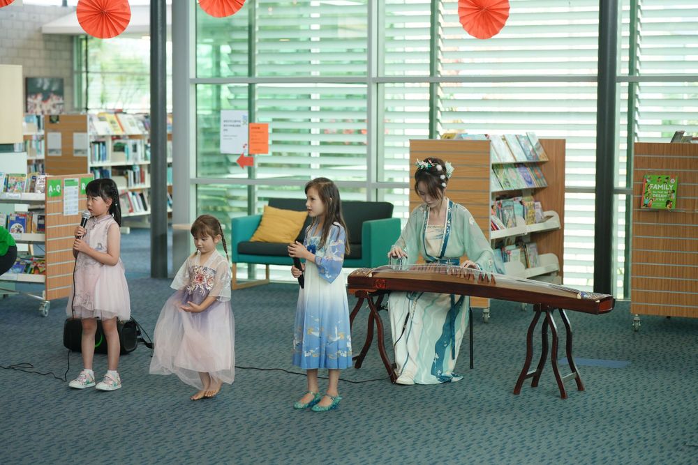 Library New Year event photography featuring a beautiful traditional Hanfu Guzheng performance, by an Auckland photographer.