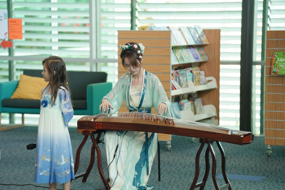 Library New Year event photography featuring a beautiful traditional Hanfu Guzheng performance, by an Auckland photographer.