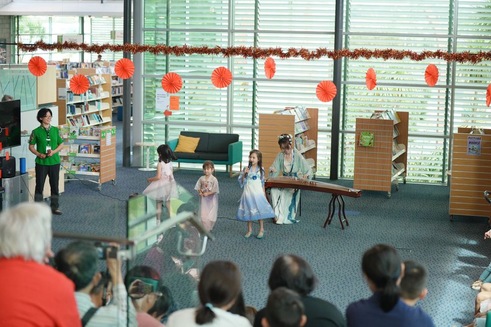 Library New Year event photography featuring a beautiful traditional Hanfu Guzheng performance, by an Auckland photographer.