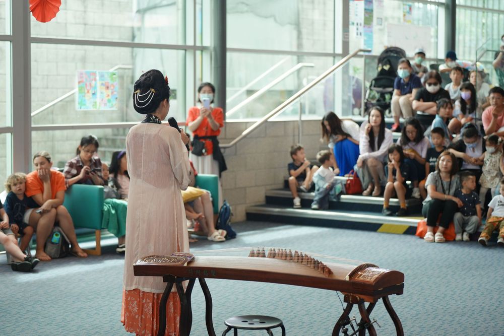 Library New Year event photography featuring a beautiful traditional Hanfu Guzheng performance, by an Auckland photographer.