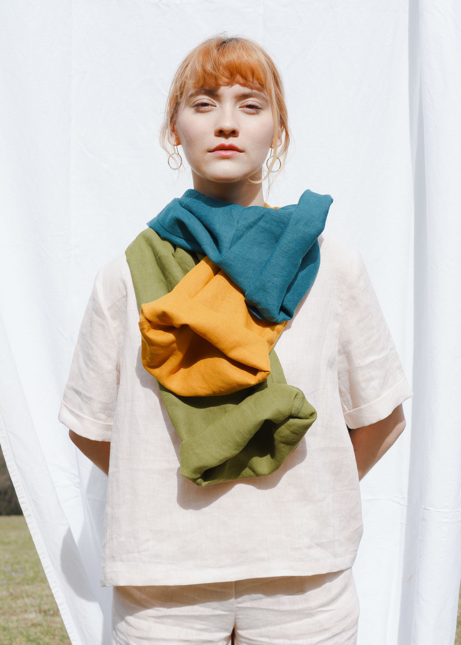 Imagefotografie stoff.werk, sonnig, kontrastreich, Leinenkleidung in starken Farben, weibliches Model, rothaarig, ernster Blick