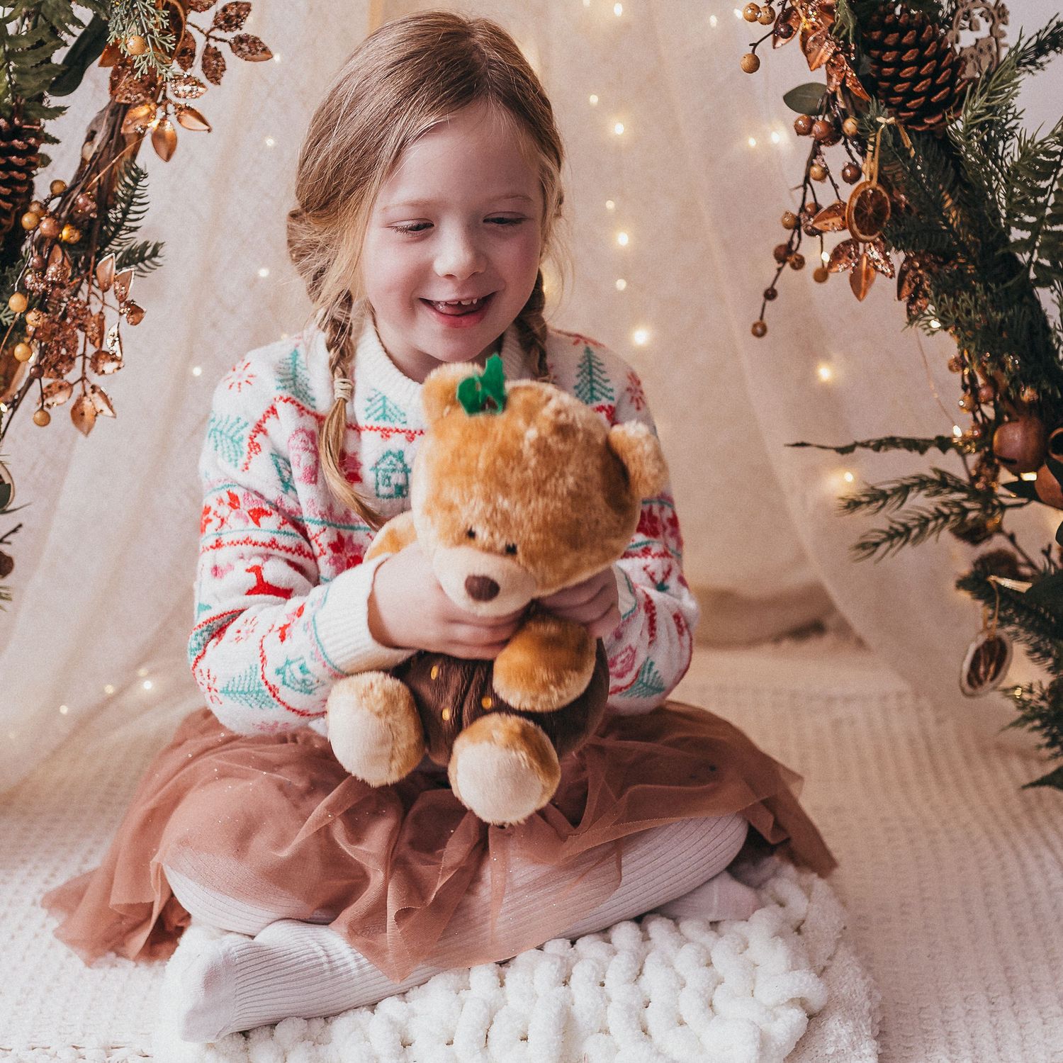 cosy christmas photo of little girl holding teddy bear