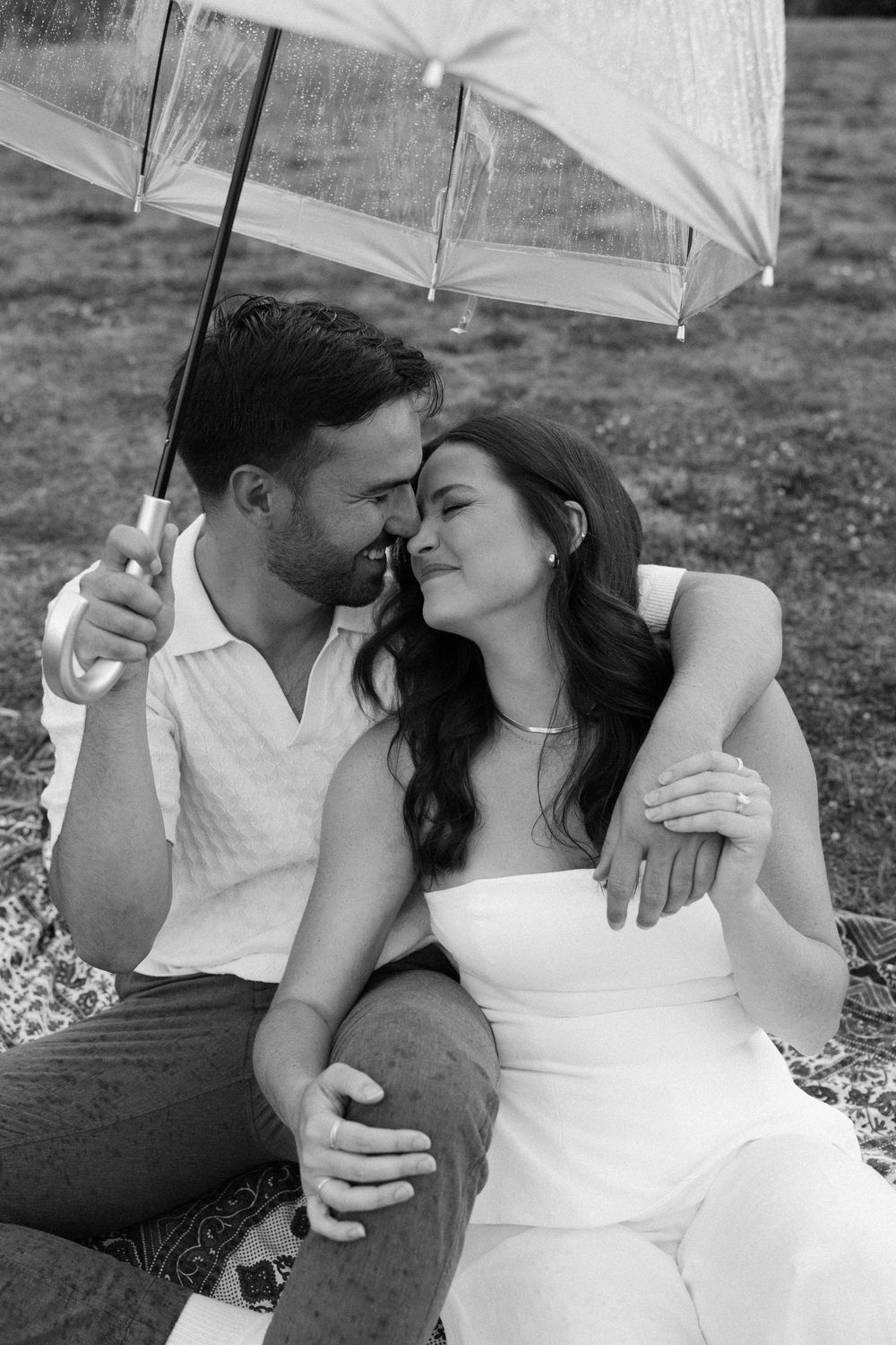 A romantic photoshoot series under a white umbrella showing intimate moments in black and white.