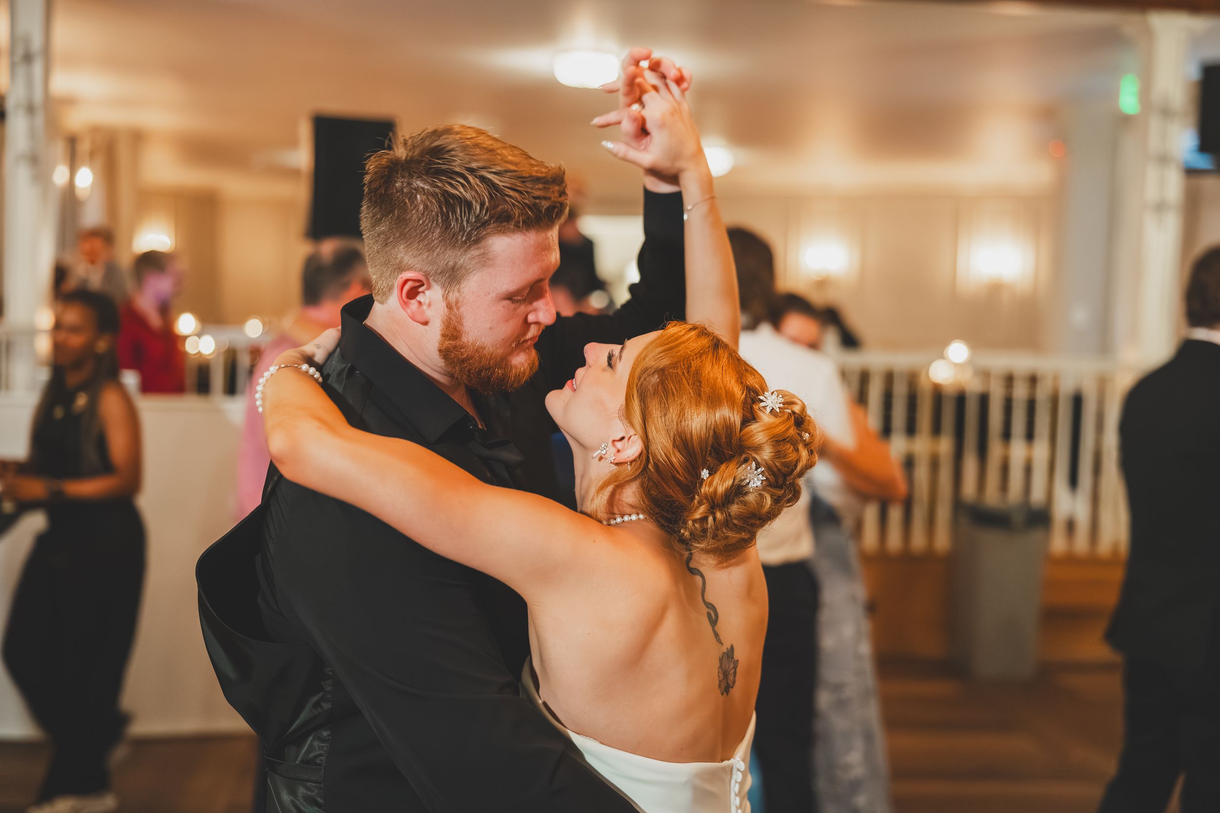 A couple shares an intimate dance together during their first dance as husband and wife dancing to die with a smile by bruno mars
