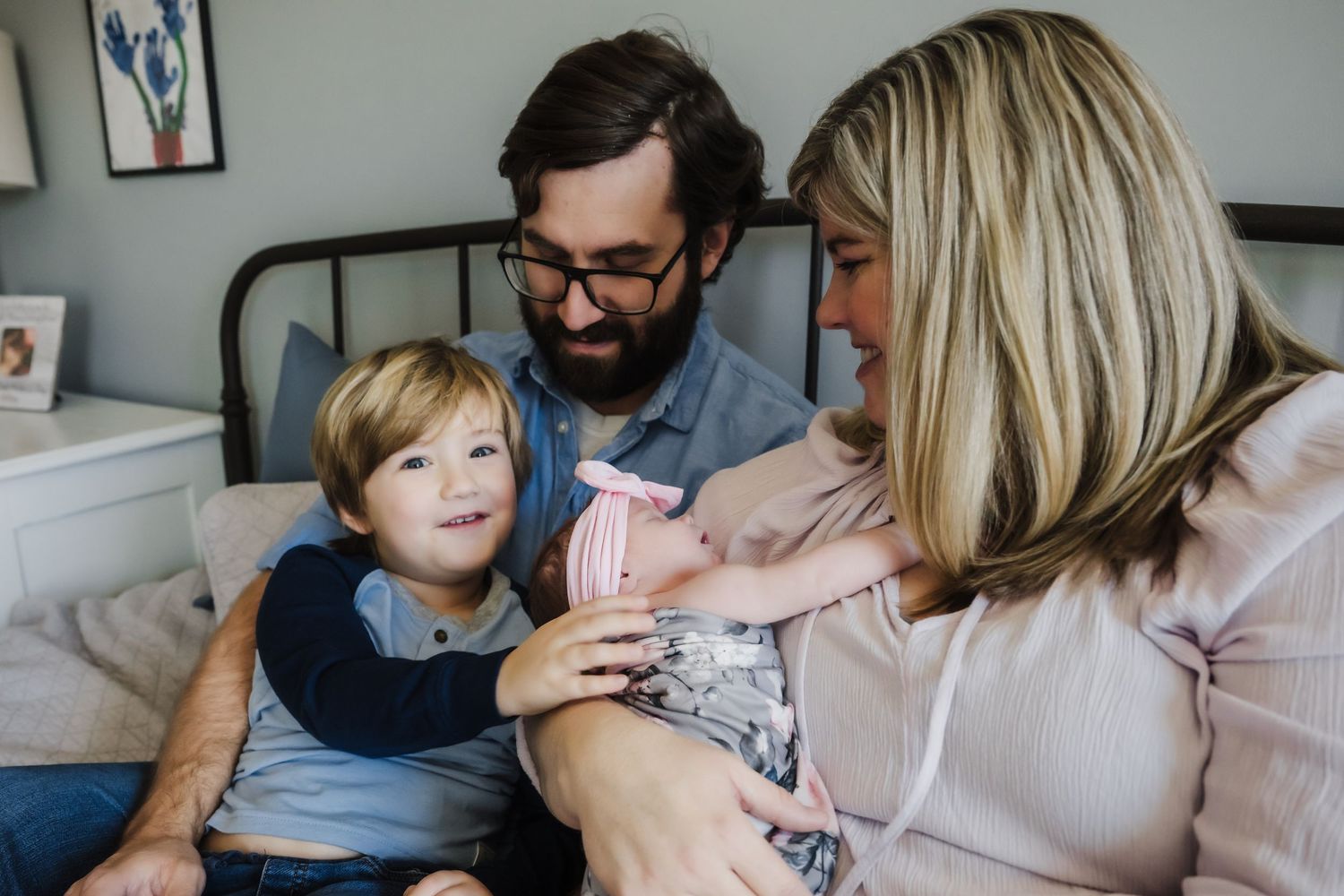 Candid lifestyle photography of family relaxing together on a couch.