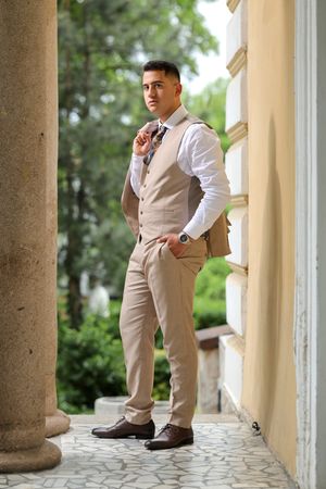 A sequence showing different poses of someone in formal attire along a colonnade with classical columns.