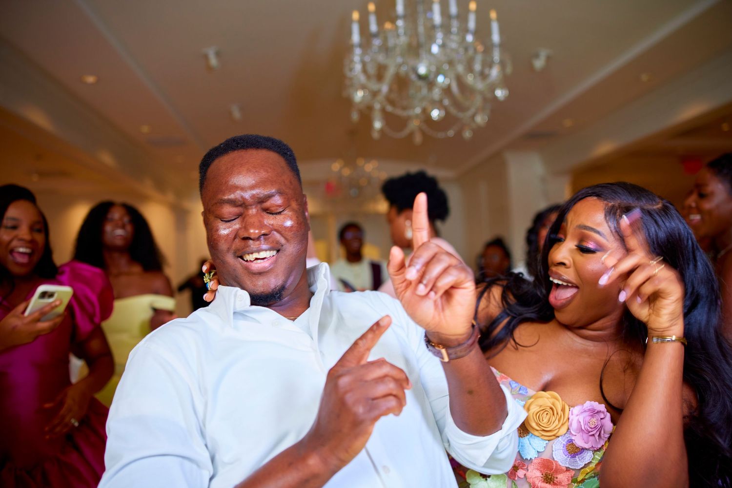 Guests dancing and celebrating with joy at a festive indoor reception event.