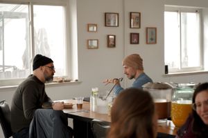 Two people having coffee and conversation at a casual cafe table.