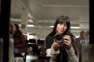 Photographer taking a self-portrait with a professional camera in an office space.