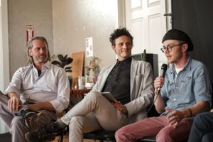 Three speakers participating in a panel discussion in a bright indoor setting.
