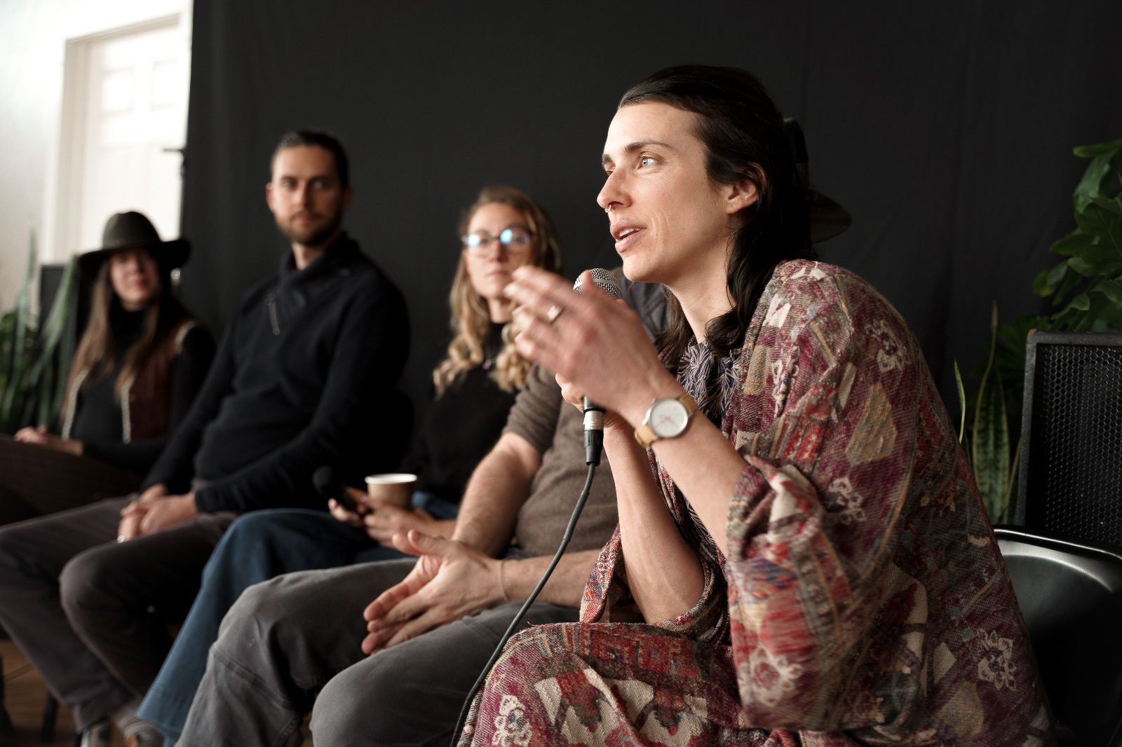 Group of people listening intently during an animated discussion in a modern space.