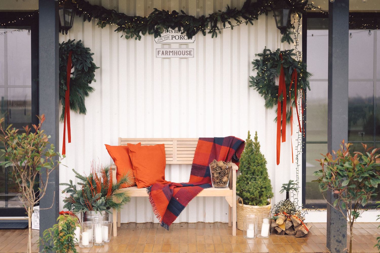 Black Christmas garland decorates a white wall with festive red ribbons and greenery for the holiday season.