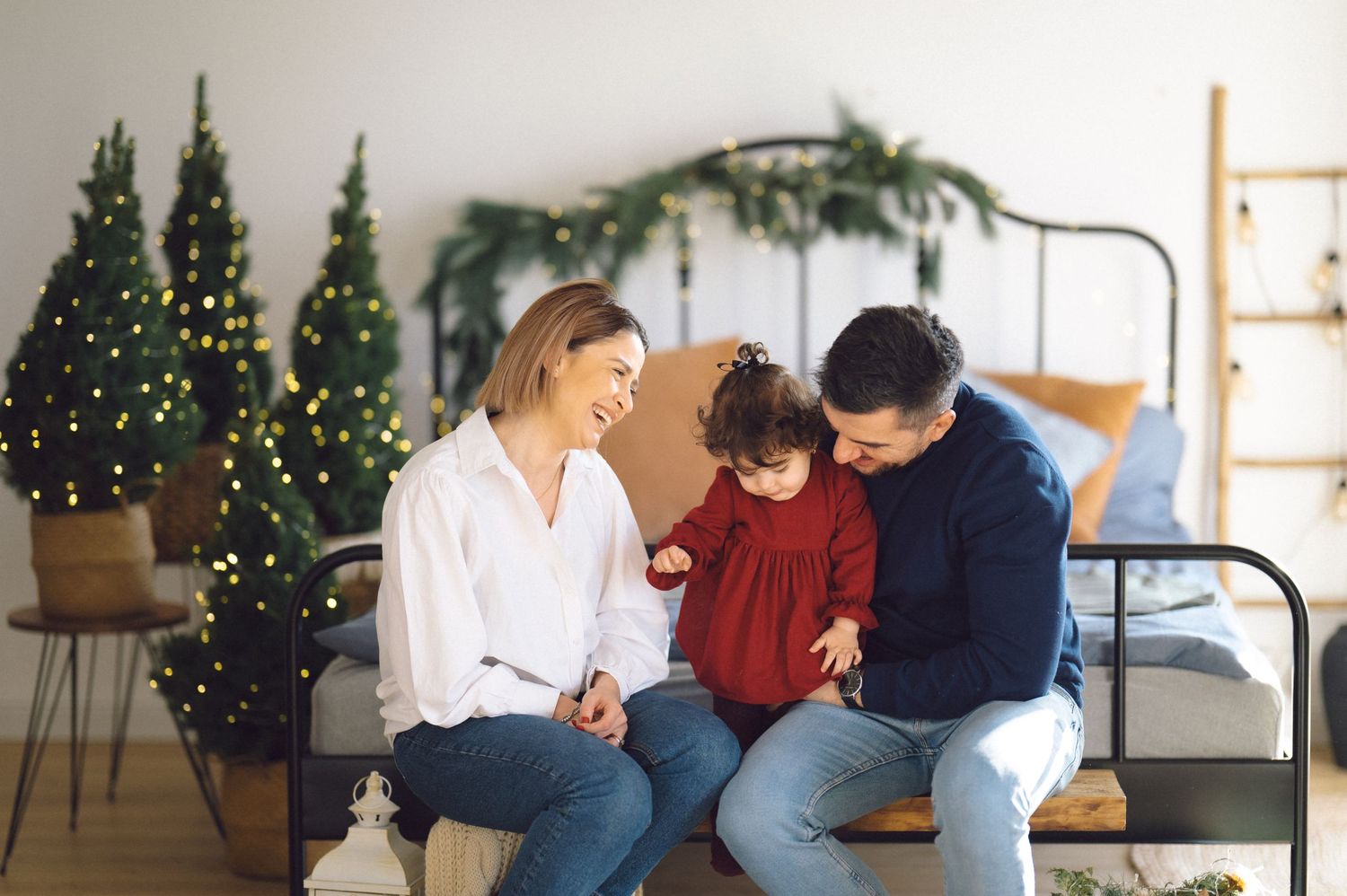 Cozy windowside scene with holiday greenery and decorative lighting in a modern living room interior.
