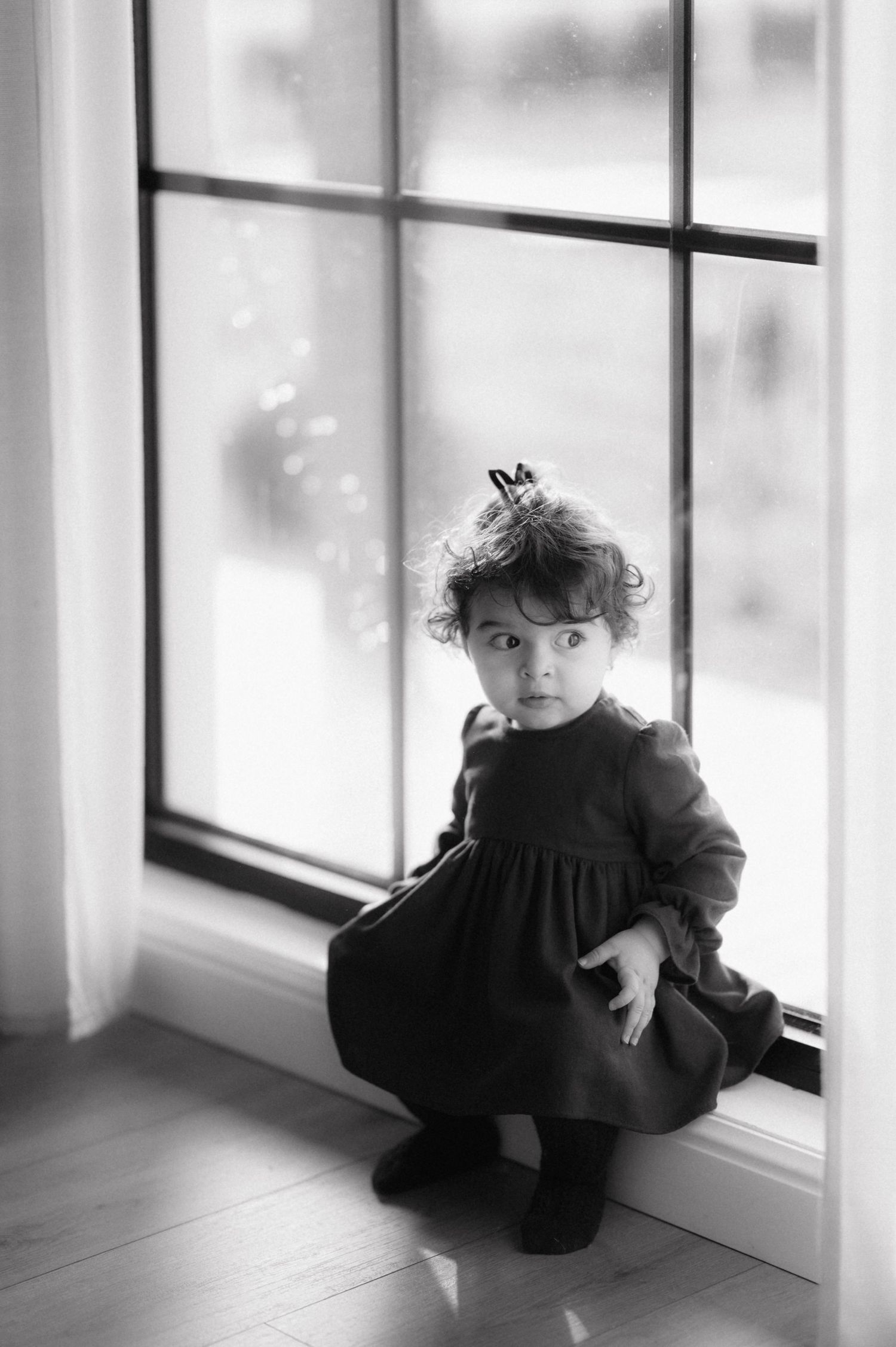 A black and white photo series shows a child sitting by a window, creating a moody artistic composition.