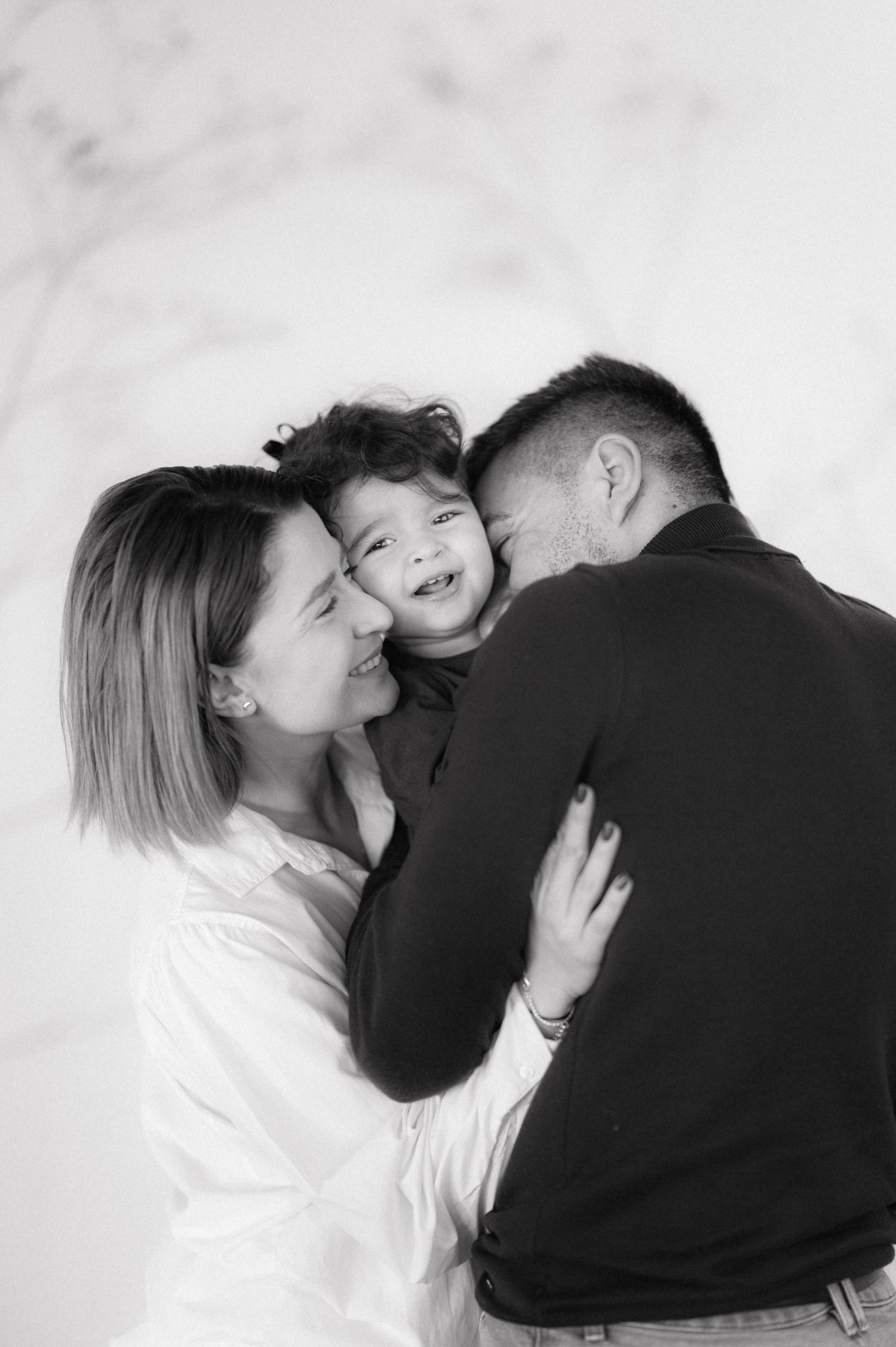 A heartwarming black and white family portrait showing tender moments of affection and joy together.