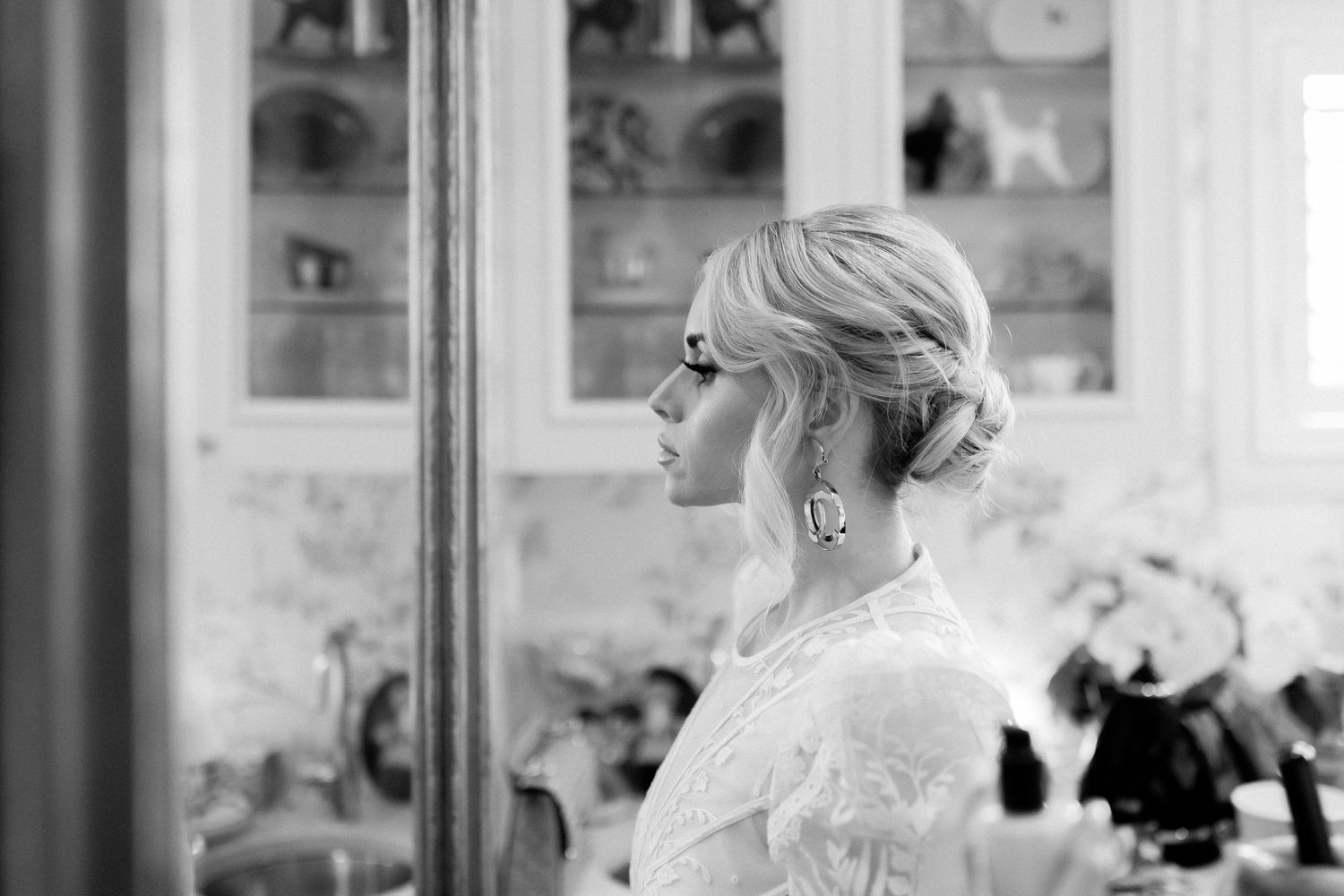 A delicate montage of black and white photos showing closeups of lace dress details in an indoor setting.
