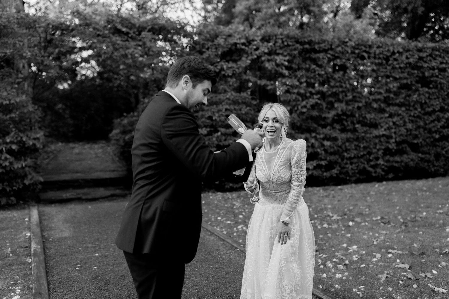 Black and white wedding photos show couple in romantic outdoor garden setting during intimate ceremony moments.