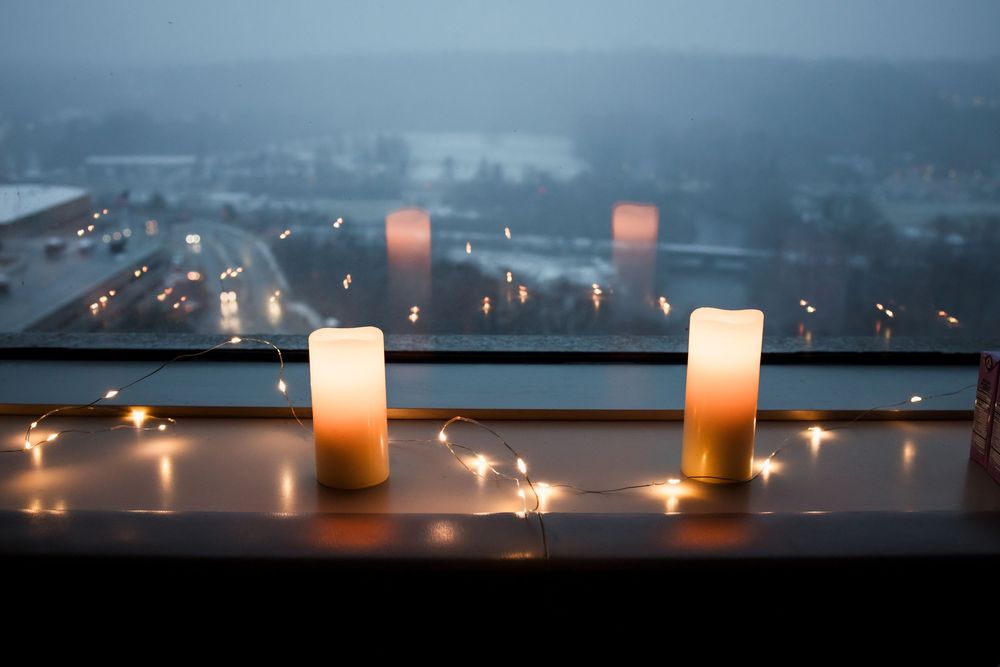 Row of glowing candles creating a peaceful ambiance against a dusky blue background.
