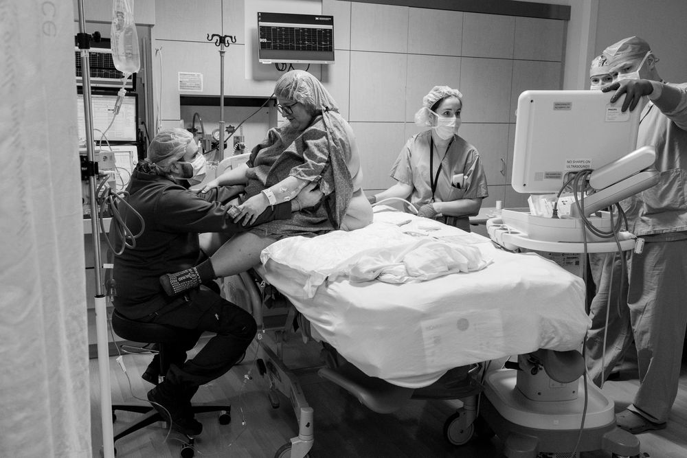 Healthcare providers performing medical procedures in a clinical setting.