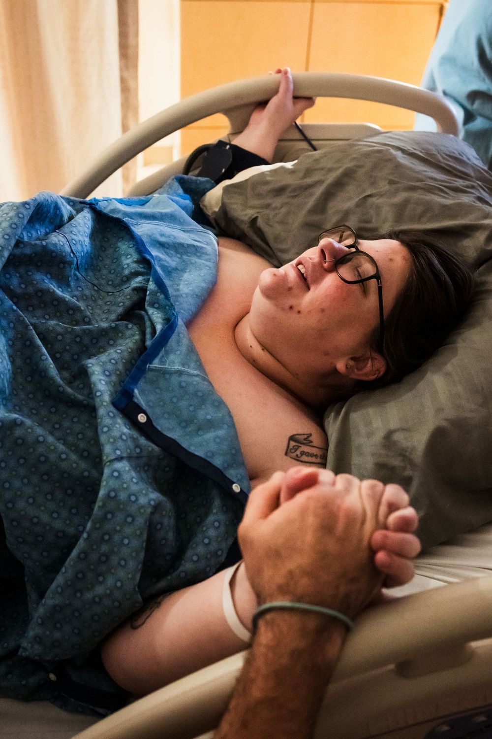 Patient wearing glasses resting in a hospital bed during treatment.