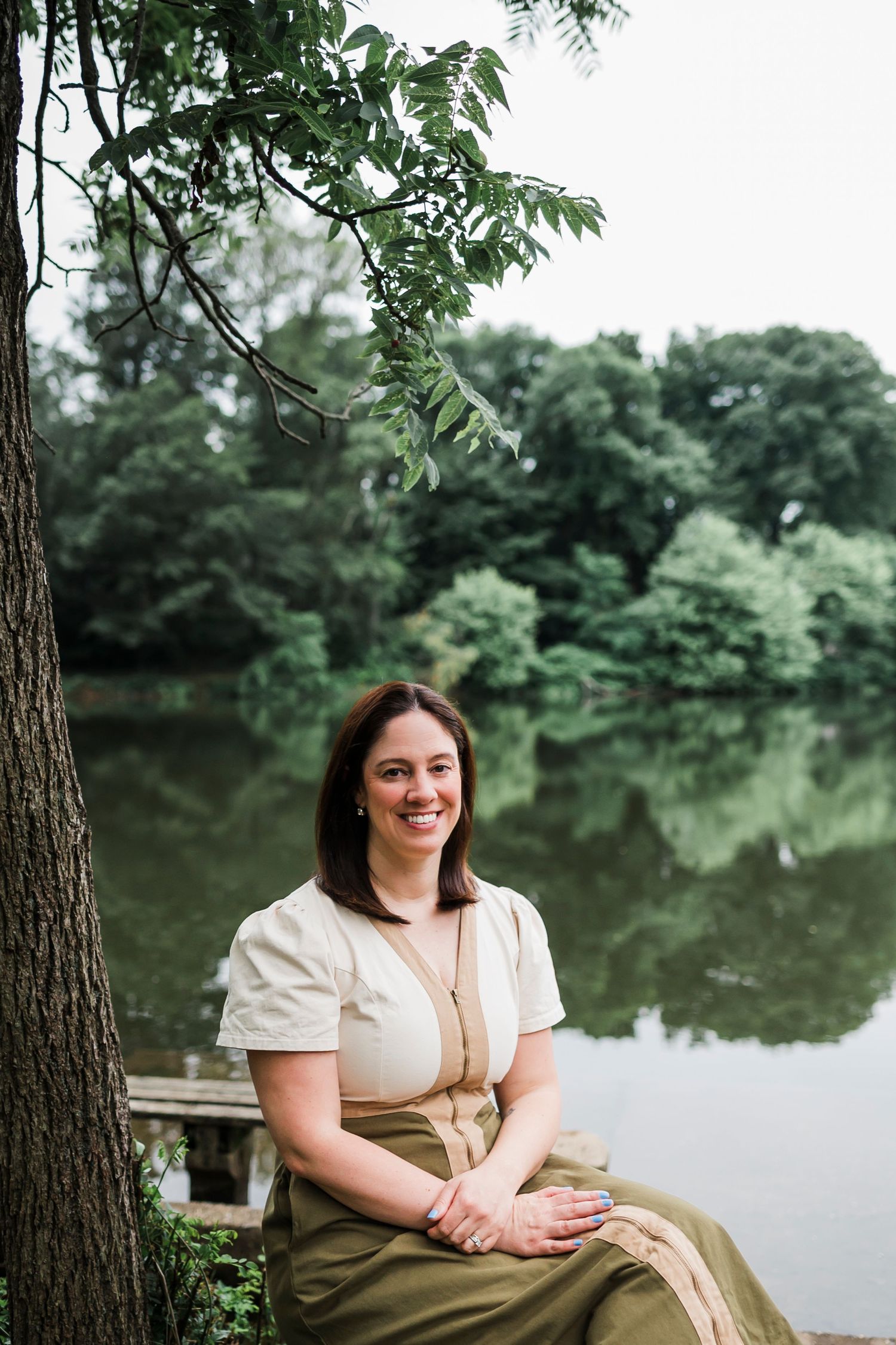 A group fitness class doing downward dog poses on colorful yoga mats in a bright studio space.