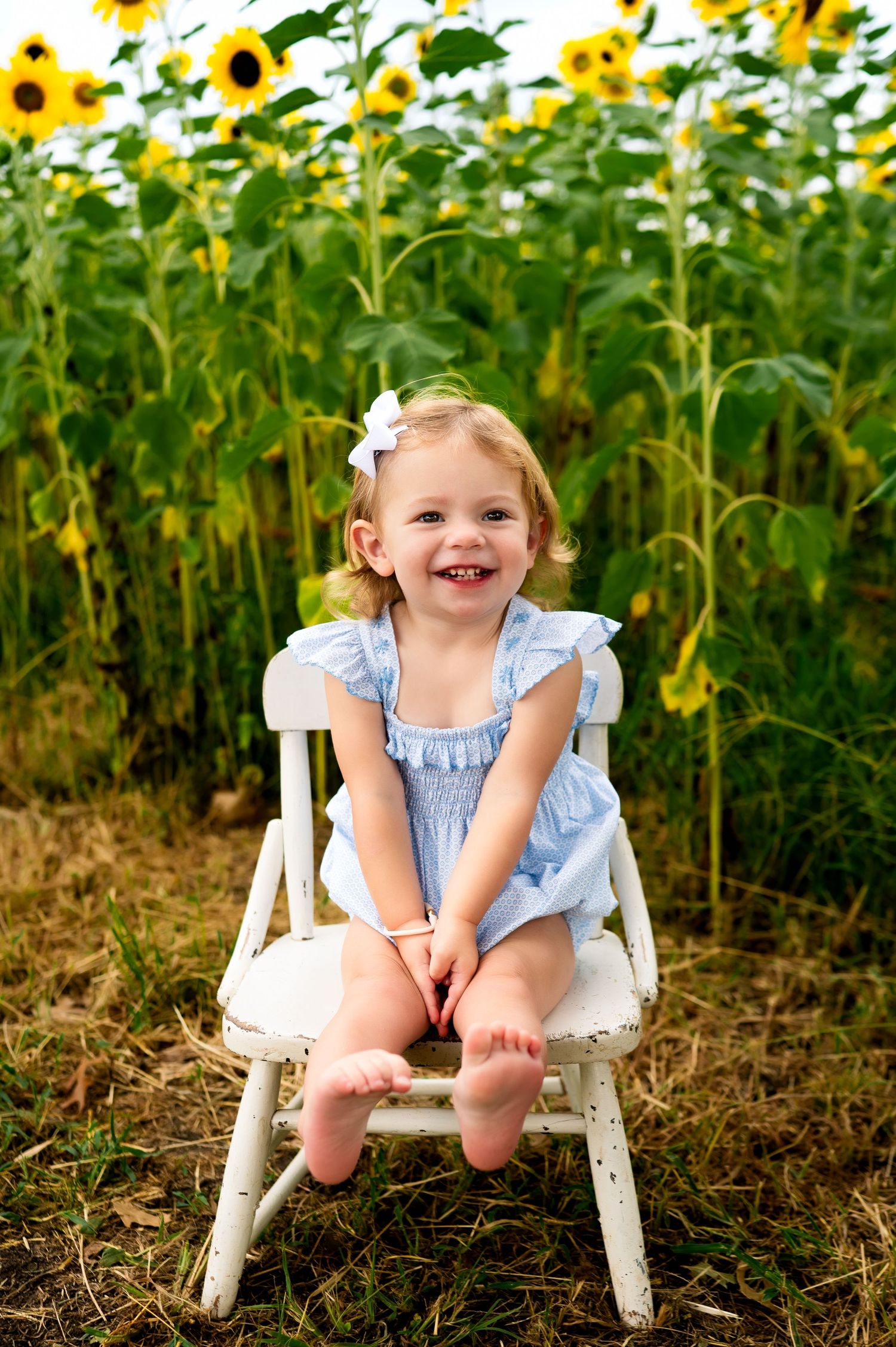 dallas area childhood portrait of young smiling girl in sunflower field; mommy and me mini photoshoot