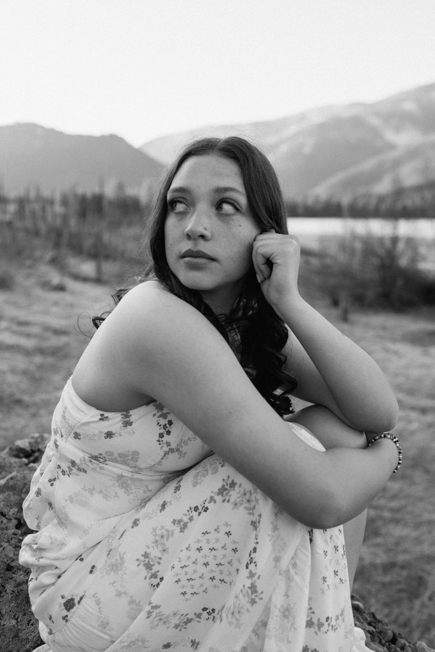 Black and white portrait with mountains and nature in background.