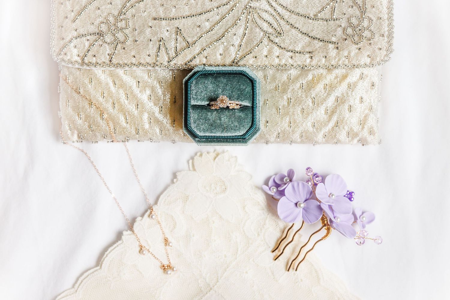 Vintage lace wedding details with antique invitations, pastel flowers, and ornate metallic accessories creating a romantic setup.
