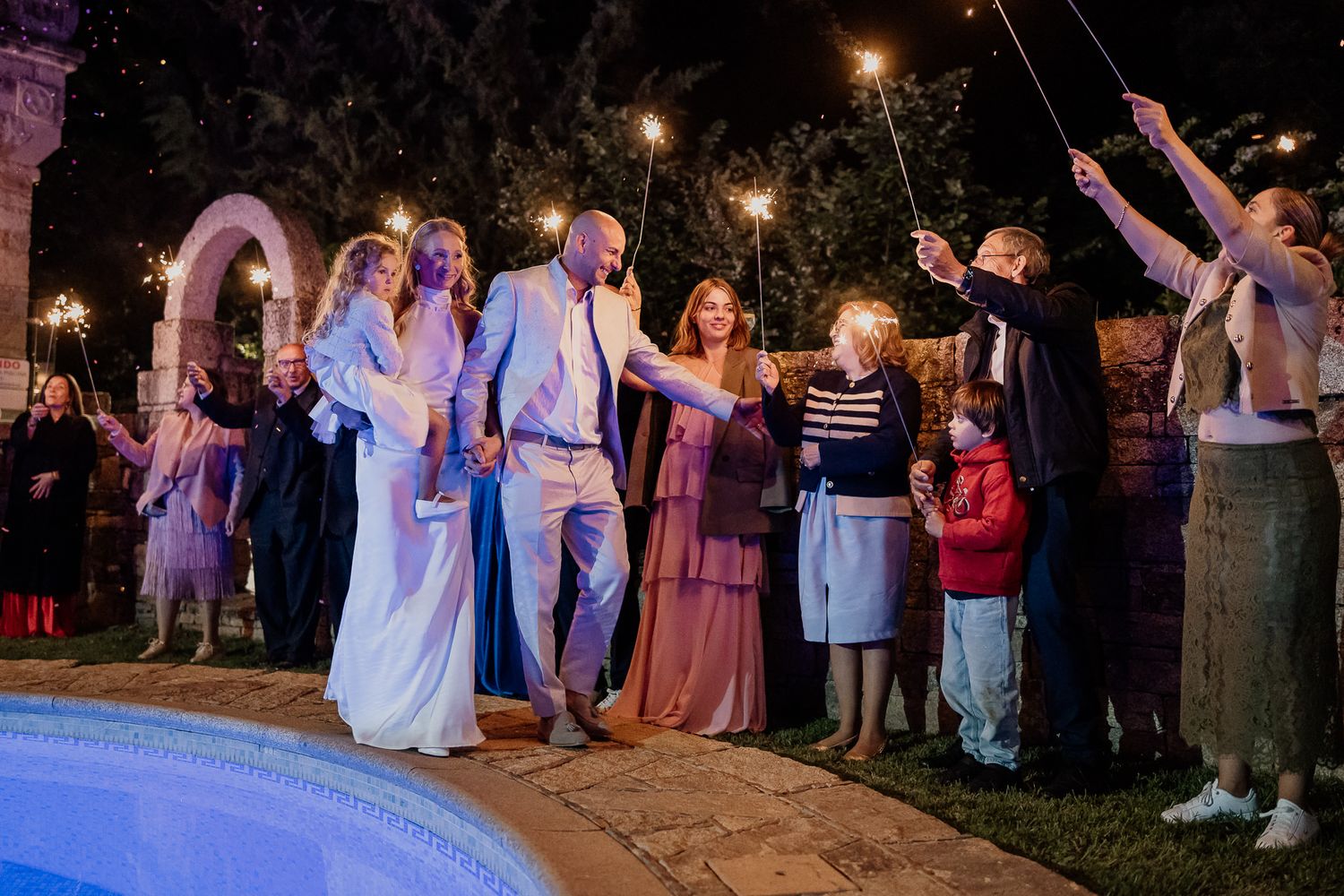 A rustic stone building with arches provides a romantic backdrop for wedding photos.