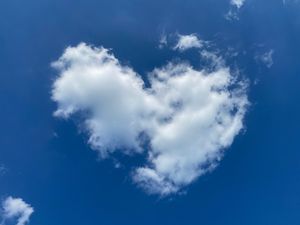 White puffy clouds drift across a vibrant blue sky during a sunny day.