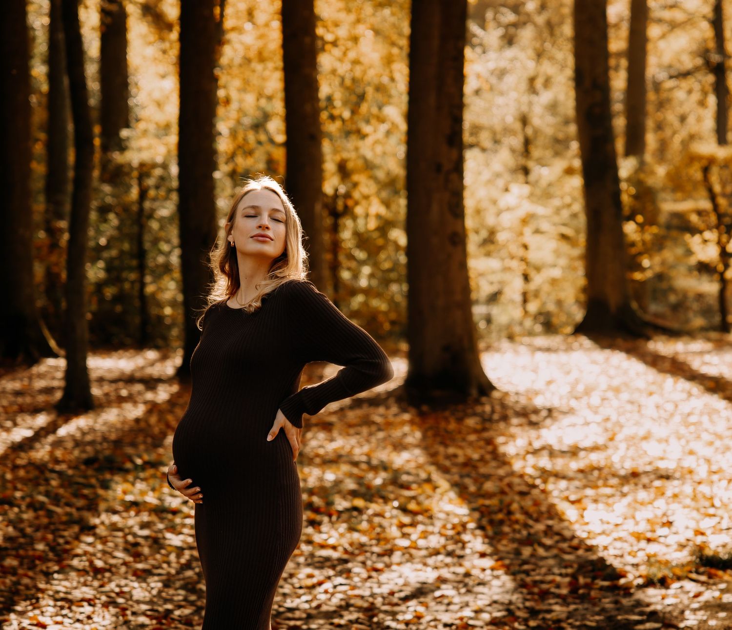 Shooting photo grossesse en extérieur : femme enceinte posant en forêt en Belgique, style naturel et authentique.