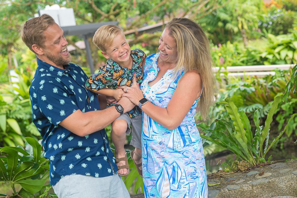 A couple in blue and white outfits share a joyful moment together in a lush garden setting.