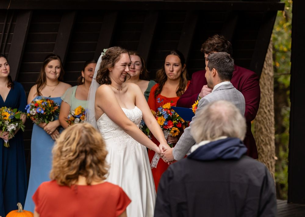 Bride in white strapless gown exchanges vows with partner at outdoor fall wedding ceremony at Platte River State Park Amphitheater