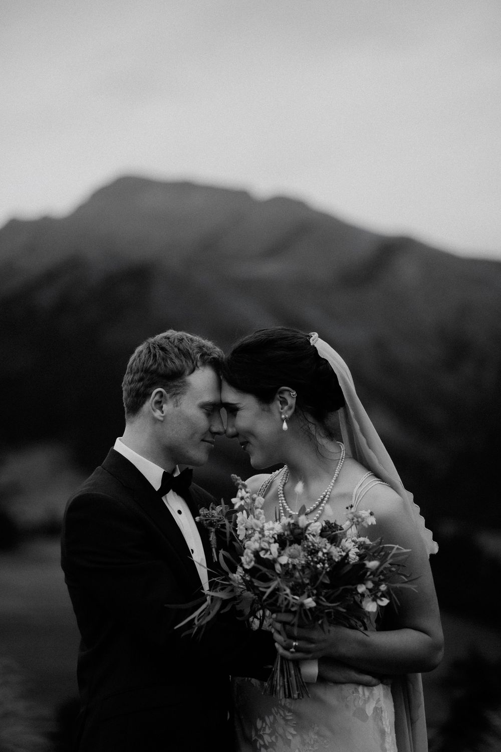 A romantic black and white wedding portrait of a couple sharing an intimate hongi, a traditional Maori greeting at Lookout Lodge, Wanaka.