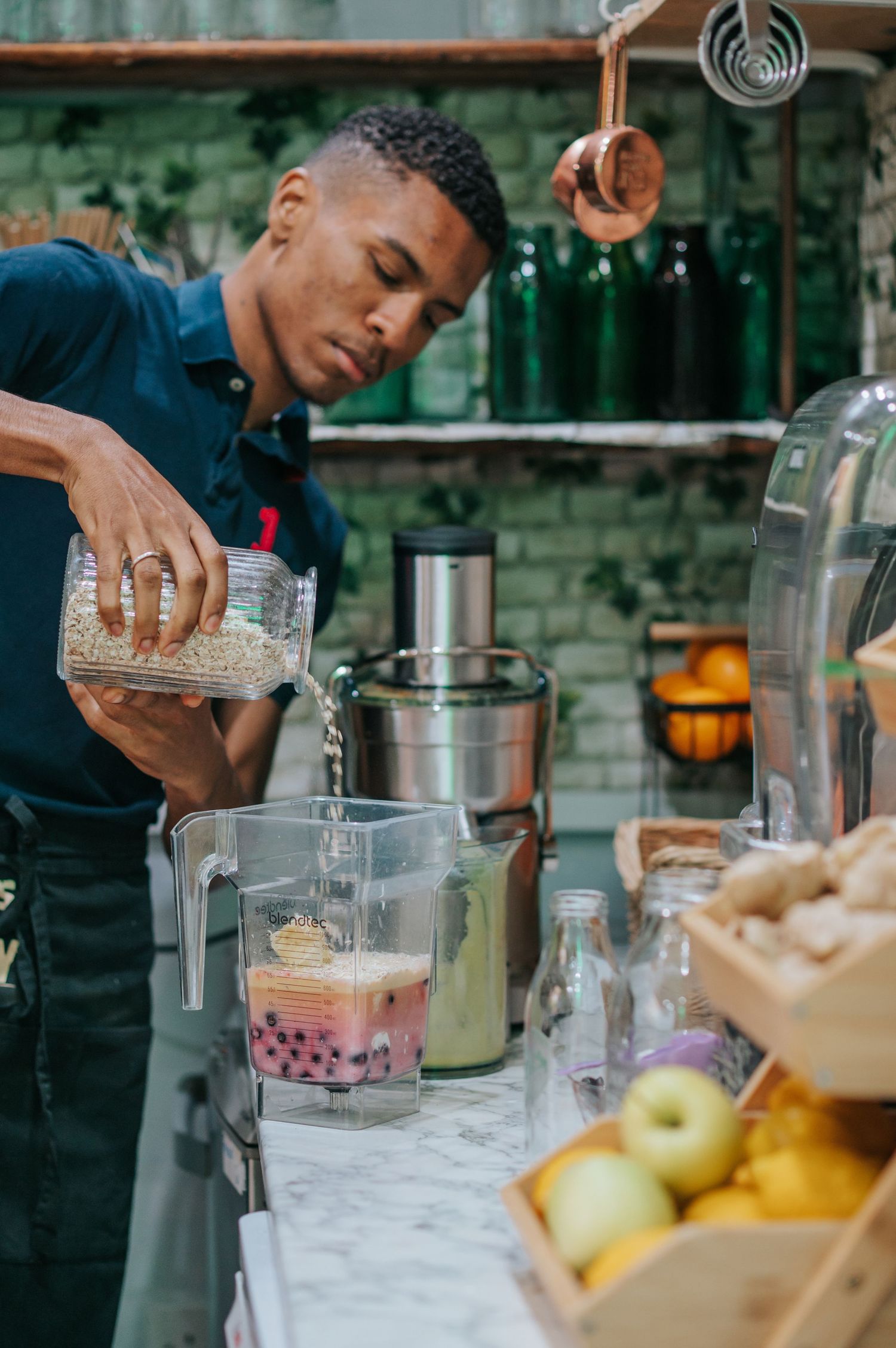 lifestyle photography of man making a smoothie in a restaurant