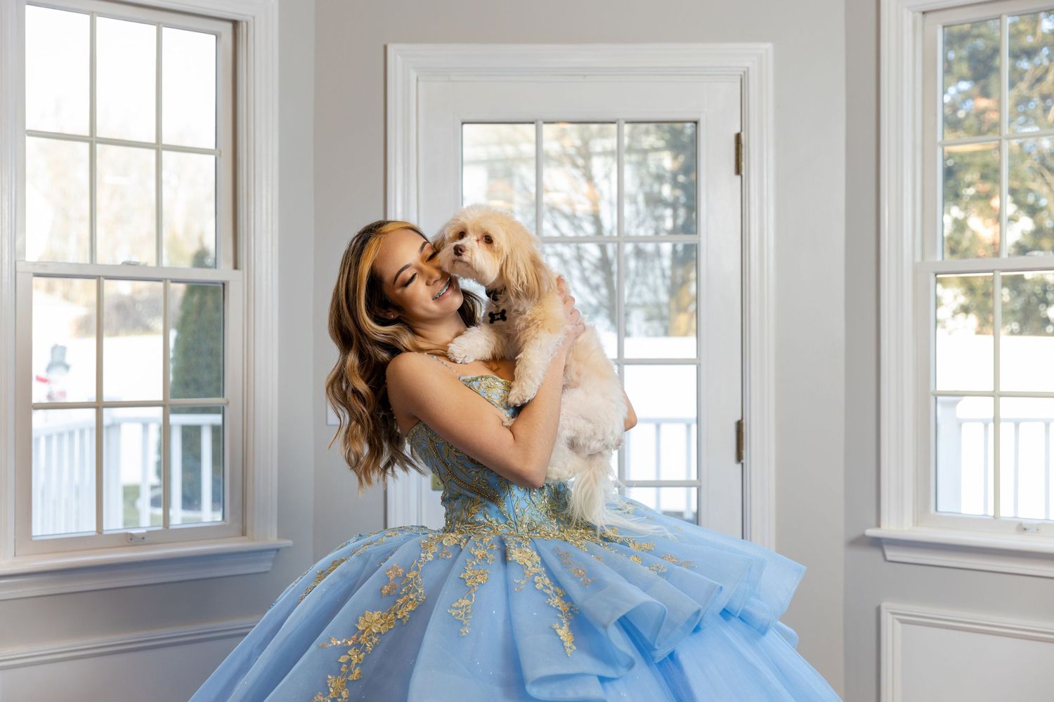 Elegant light blue ball gown portrait with golden retriever in bright sunlit room.