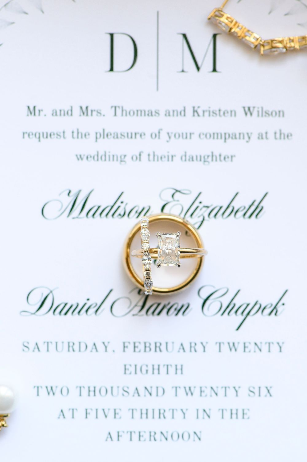 Elegant wedding invitation for Madison Elizabeth and Daniel Aaron Chapek, February 28, 2026, with gold rings.