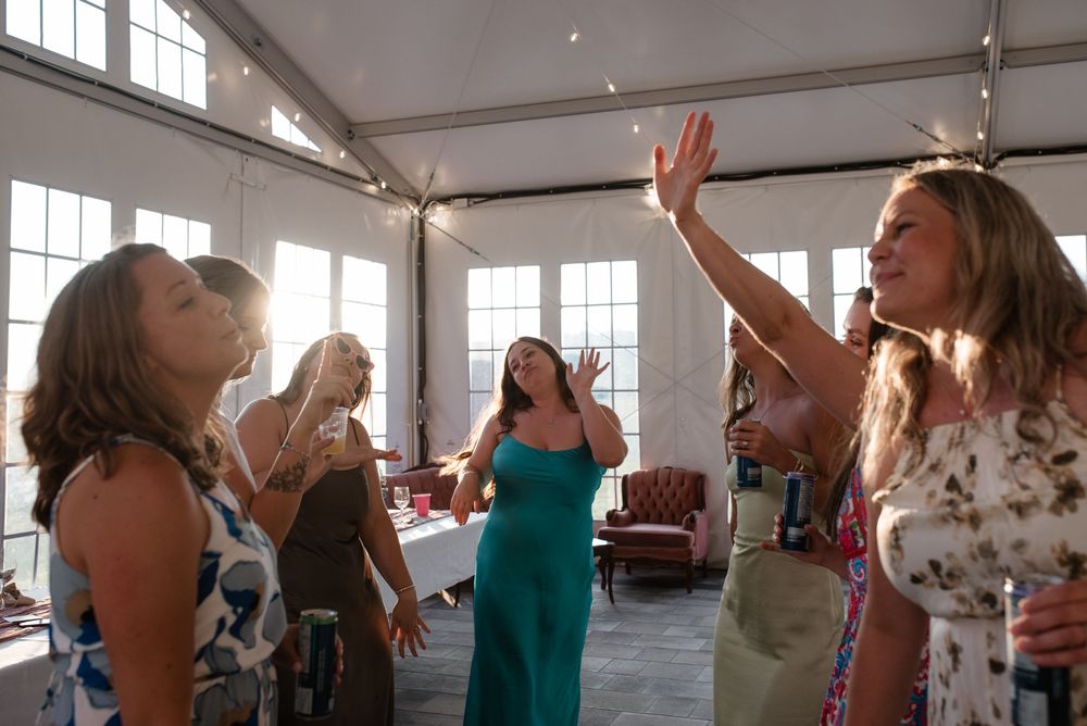 A group of people participate in a dance or movement class in a bright studio with large windows.